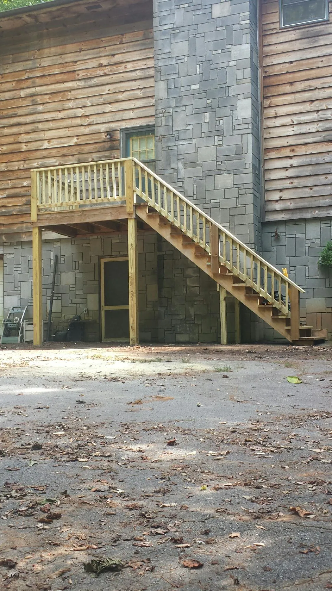 New pressure treated deck and stair landing on a log home in Easton