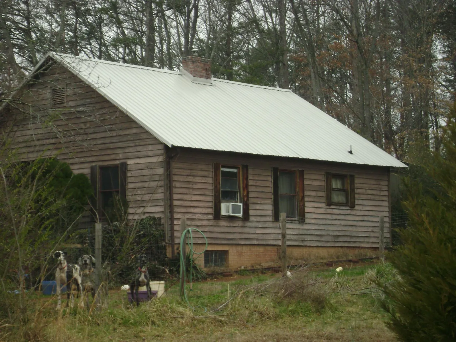 White metal roof on an old wood sided farmhouse, from a Metal Roof Installation job in Easton